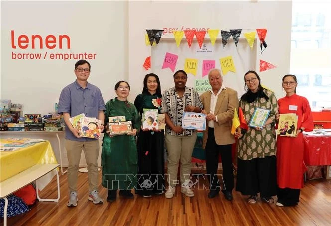 Des représentants de l'Union générale des Vietnamiens de Belgique (UGVB) remettent des livres à la bibliothèque Muntpunt. Photo: VNA
