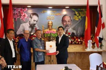 L’ambassadeur vietnamien, Pham Viet Hung (à droite) remet un cadeau à ,Nguyen Van Tri, président de l'Association des Vietnamiens de Sa Kaeo. Photo : VNA