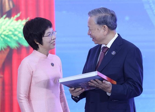 La directrice générale de la VNA, Vu Viet Trang, offre au secrétaire général To Lam l’album photo « La gloire appartient à jamais au Peuple ». Photo : VNA vna-potal-tong-bi-thu-to-lam-du-le-ky-niem-80-nam-ngay-truyen-thong-thong-tan-xa-viet-nam-8274113.jpg