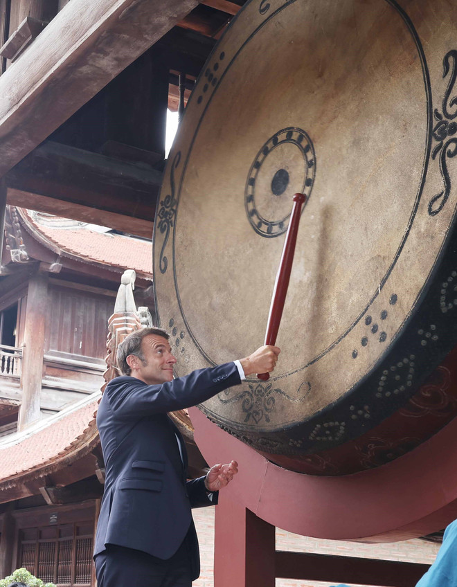 Le président Emmanuel Macron participe au rituel du tambour « Sam » (tonnerre) dans l’enceinte du Temple de la Littérature. Photo: VNA vna-potal-tong-bi-thu-to-lam-va-phu-nhan-cung-tong-thong-phap-va-phu-nhan-tham-van-mieu-quoc-tu-giam-8054996.jpg