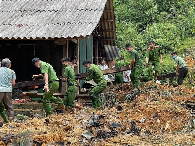 Des policienrs aident des sinistrés à surmonter les conséquences des inondations. Photo: VNA cong-an-180825-1.jpg