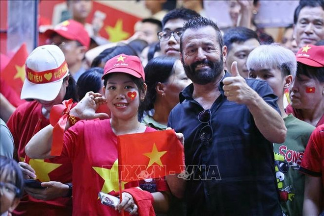Un touriste étranger se joint à la joie partagée de la population de Hanoï. Photo : VNA du-khach-nuoc-ngoai1.jpg