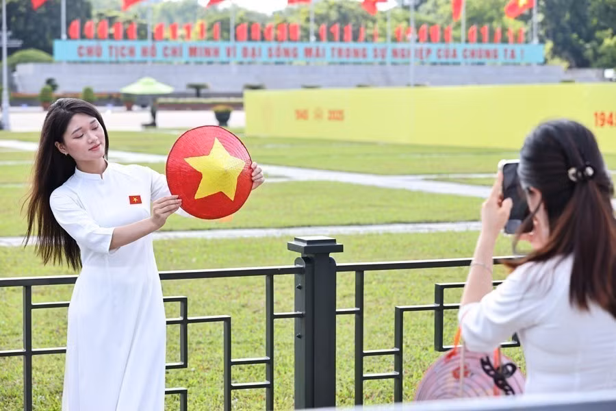 De jeunes femmes revêtent l'ao dai, la tenue traditionnelle vietnamienne, pour célébrer le 80e anniversaire de la Révolution d'août et de la Fête nationale. Photo : VNA
