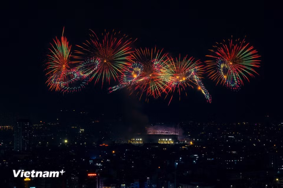 La lumière des feux d'artifice rehausse encore le rouge du drapeau du Parti, renforçant la confiance inébranlable dans le nouvel avenir du pays. Photo : Vietnam+