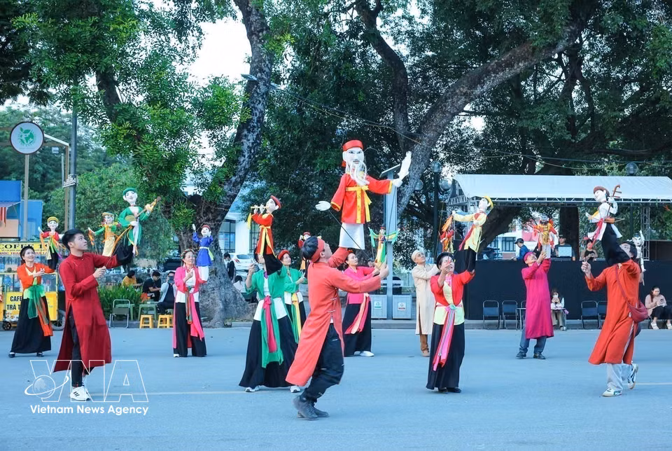 La troupe de marionnettes Te Tieu présente un spectacle dans la rue piétonne Tran Nhan Tong, attirant le regard et l’intérêt des passants. Photo : VNA