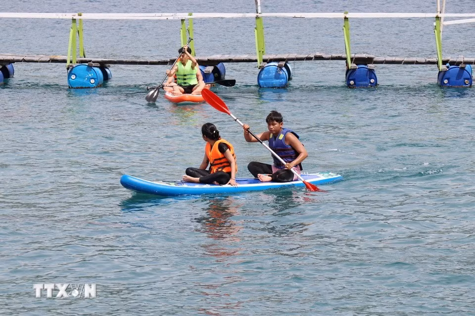 Les visiteurs peuvent pratiquer des activités comme le kayak, sur la baie de Vinh Hy. Photo : VNA