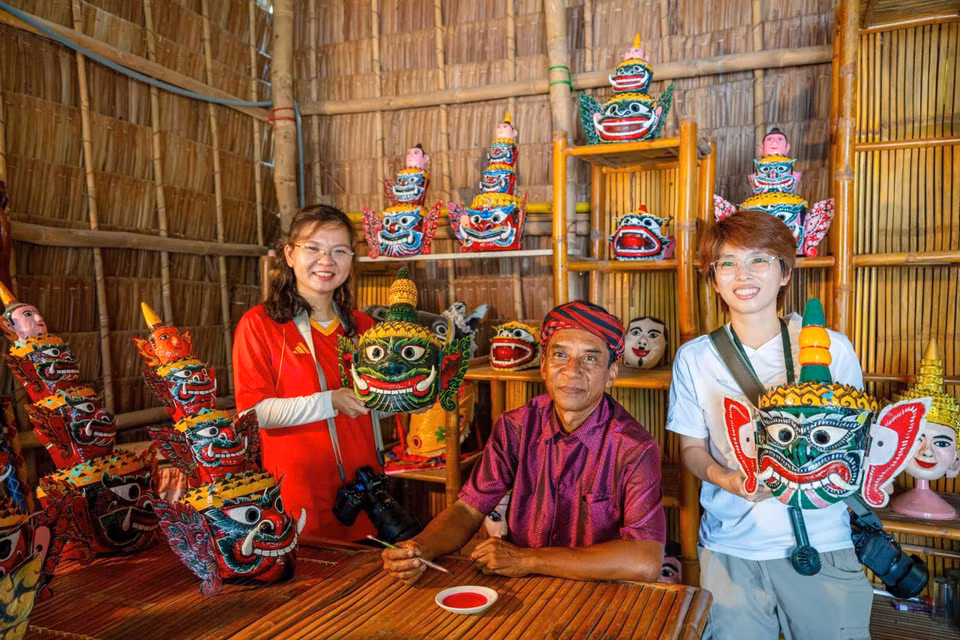 Des visiteurs découvrent avec intérêt les techniques de fabrication des masques, un savoir-faire artisanal de la culture khmère. Photo : VNA ​