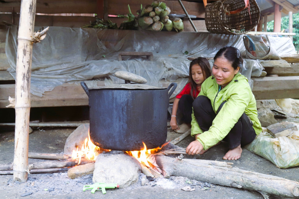 Dans le village de Bung, une femme et sa fille préparent le repas quotidien autour du foyer traditionnel de la maison. Photo : VNA