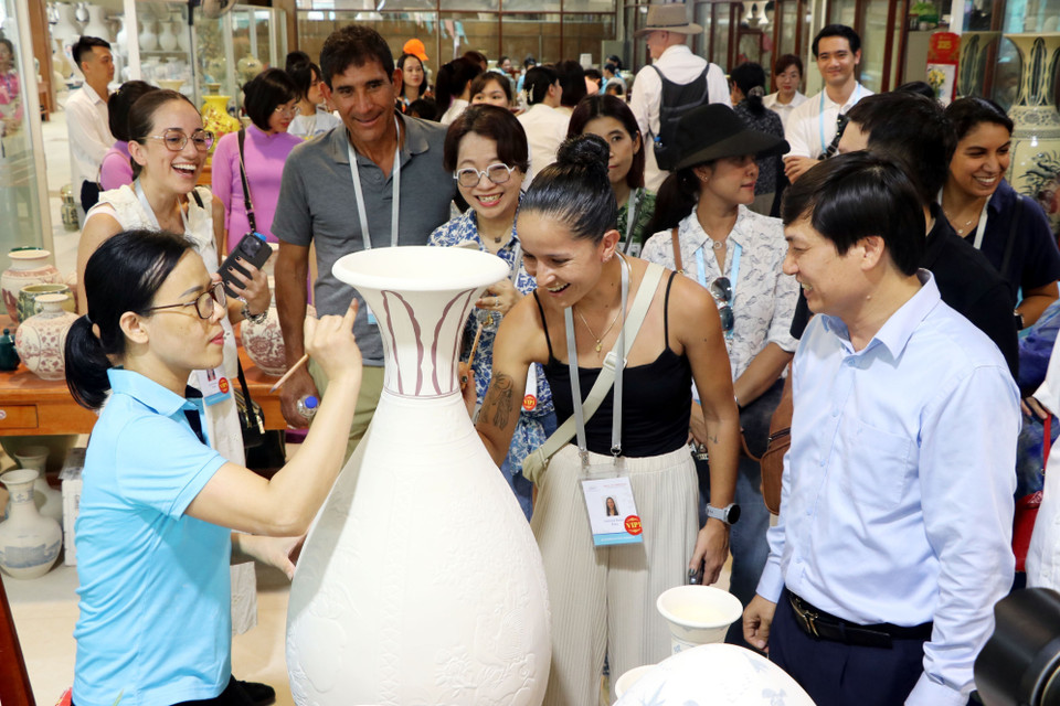 Les invités internationaux ont la chance d'explorer le processus complexe de fabrication de la poterie, d'admirer des expositions de céramiques aux couleurs vives et de s'essayer à la peinture sur des produits céramiques. Photo : VNA
