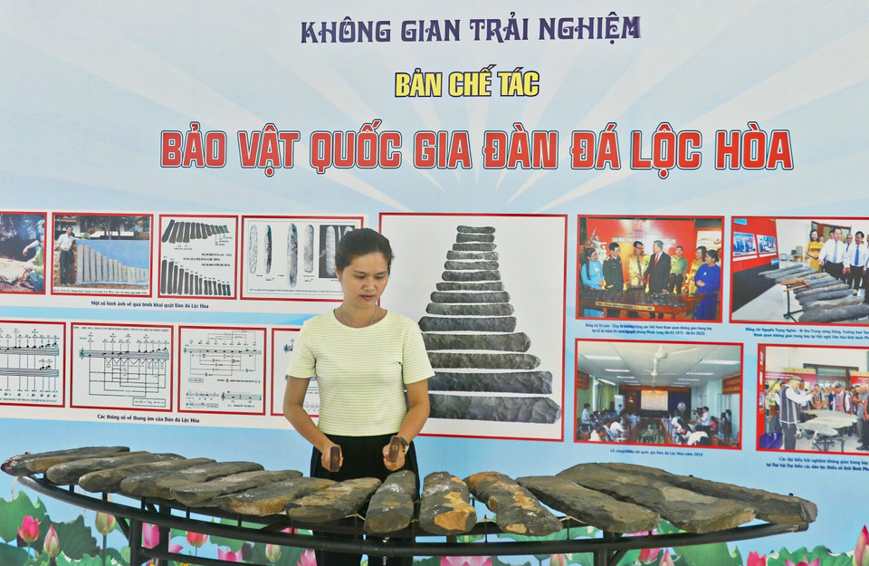 Une touriste découvre le lithophone à l'Espace culturel de Binh Phuoc, au Musée de la province de Dông Nai. Photo : VNA