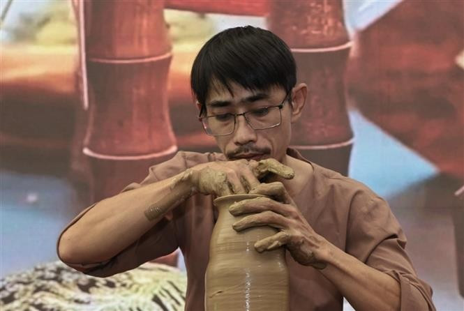 Un artisan de Huê captive le public en façonnant des poteries selon les techniques traditionnelles. Photo : VNA