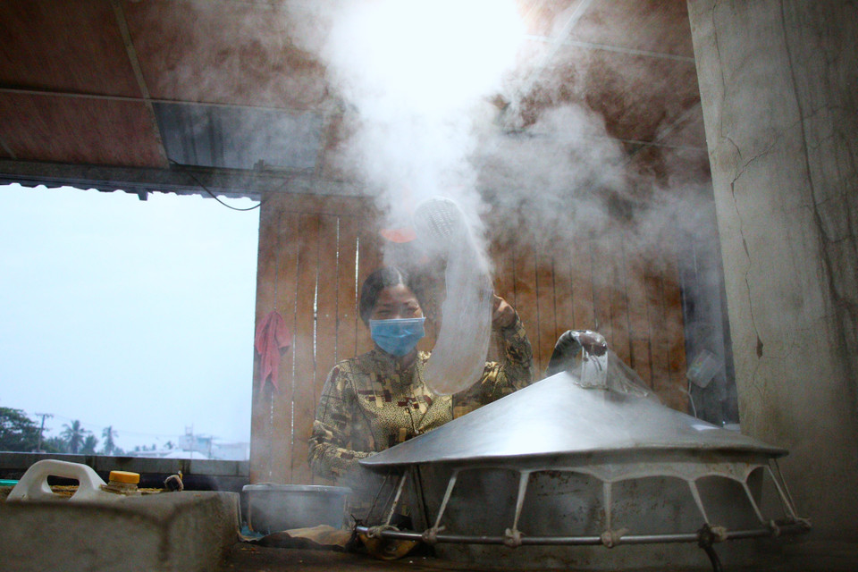 Entre deux barges remplies de pastèques et d’ananas, prenez le temps de découvrir la confection traditionnelle des galettes de riz croustillantes : un rituel simple, ancestral et profondément ancré dans la culture du delta du Mékong. Photo : VNA