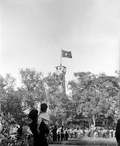 Le 10 octobre 1954, la population, pleine de joie, regarde le drapeau national flottant fièrement sur le Mât au Drapeau de Hanoï. Photo : Archives