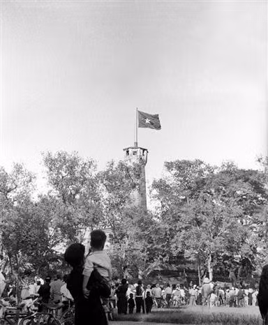 Le 10 octobre 1954, la population, pleine de joie, regarde le drapeau national flottant fièrement sur le Mât au Drapeau de Hanoï. Photo : Archives