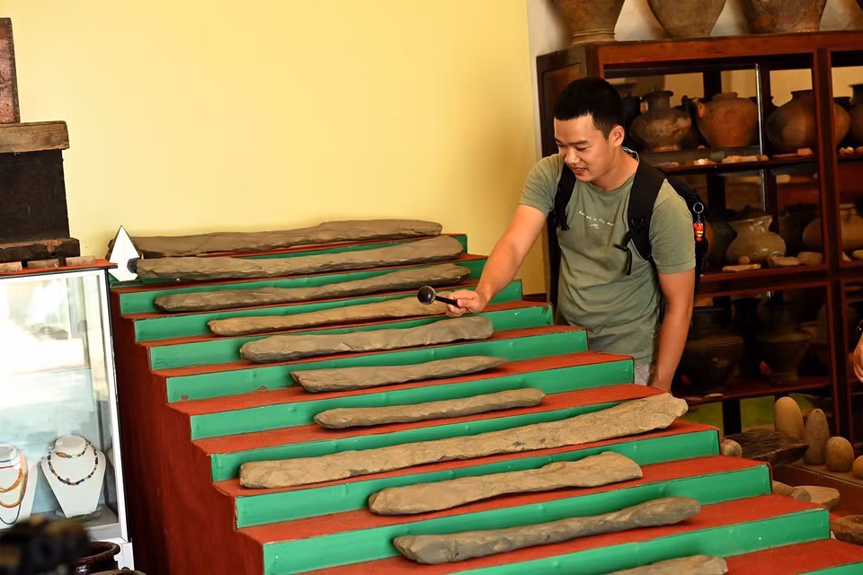 Un visiteur expérimente le lithophone Ngu âm, vieux de plus de 3 000 ans. Photo : VNA