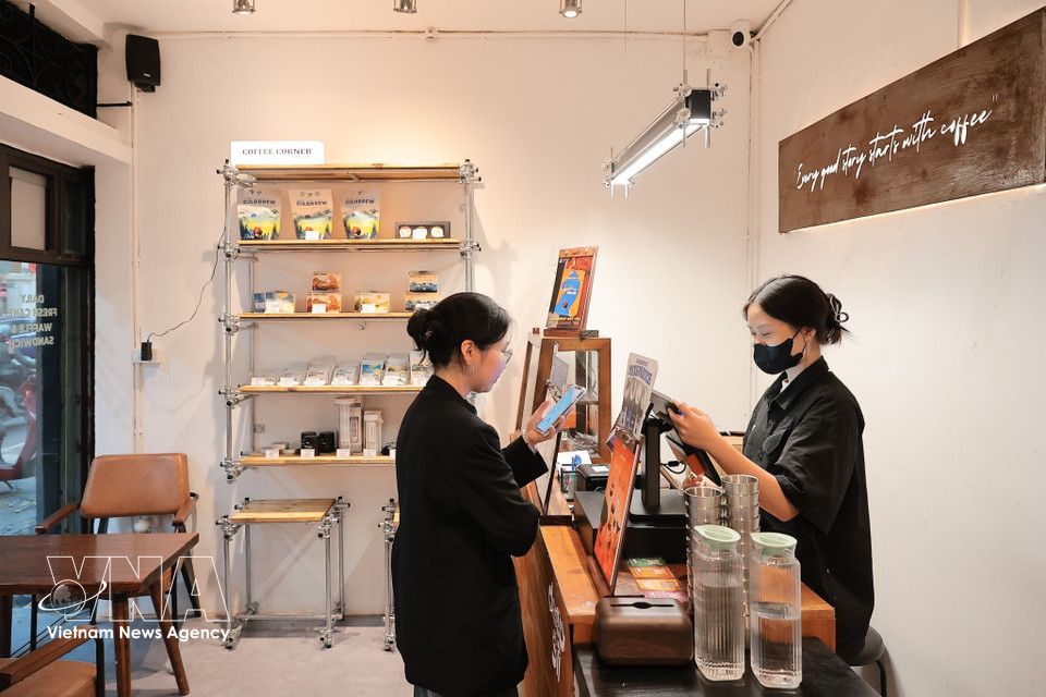 Un client utilise un code QR pour régler ses achats dans un magasin de la rue Phan Huy Chu, à Hanoï. Photo : VNA