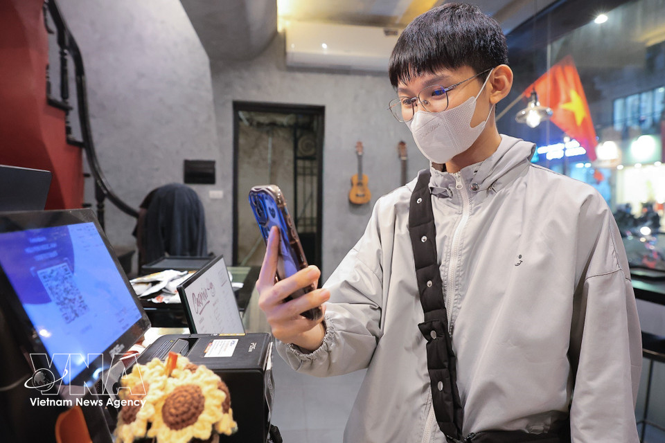 Un simple smartphone permet désormais de finaliser une transaction sécurisée en seulement quelques secondes. Photo : VNA