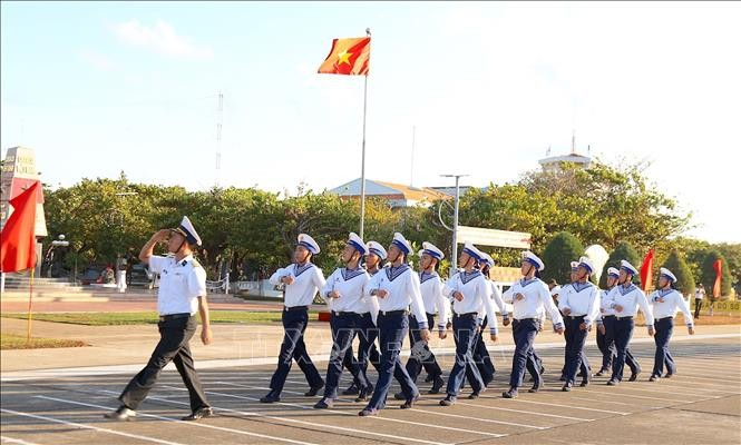 Les officiers et soldats fiers de défiler devant le drapeau national à Truong Sa. Photo : Báo Tin tức