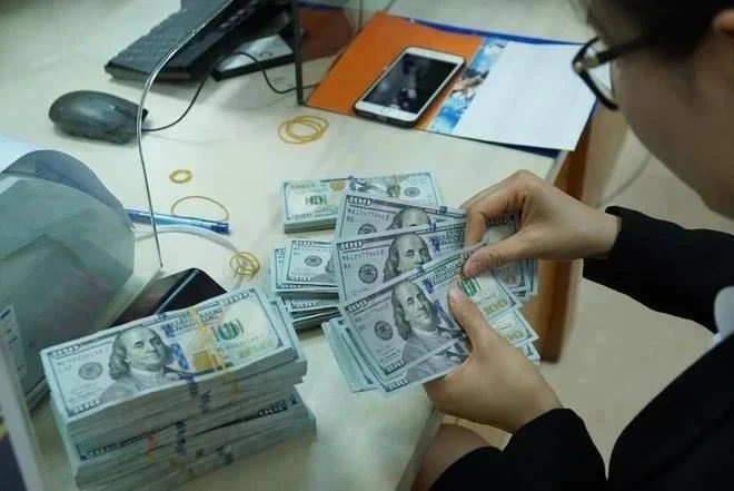 Un caissier de banque compte de l'argent dans un bureau de transaction à Hanoi. (Photo : VNA)