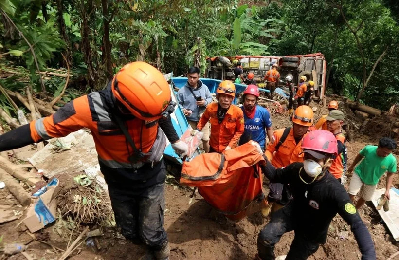 Des secouristes transfèrent le corps d'une victime sur le site d'un glissement de terrain dans le village de Cisarakan, dans la régence de Sukabumi, dans la province de Java occidental, en Indonésie, le 7 décembre. (Photo : Xinhua)