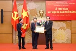 Le président de l’Assemblée nationale, Trân Thanh Mân (à gauche) remet l’Insigne des 30 ans d’appartenance au Parti au membre du Comité central du Parti, secrétaire adjoint du Comité du Parti de l’Assemblée nationale, Vu Hai Hà, à Hanoi, le 9 juillet. Photo: VNA