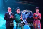 Le vice-ministre de la Culture, des Sports et du Tourisme, Ta Quang Dông, et la directrice générale de la VNA, Vu Viêt Trang, remettent le Prix «Artiste inspirant» à l'artiste Chu Bao Quê. Photo: VNA