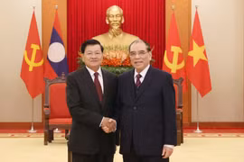 L’ancien secrétaire général du Parti Nong Duc Manh (droite) et le dirigeant lao Thongloun Sisoulith. Photo: VNA