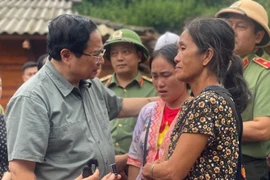 Le Premier ministre Pham Minh Chinh (gauche) et les sinistrées à Diên Biên. Photo: VNA