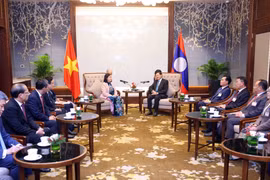 Bui Thi Minh Hoai, membre du Bureau politique et présidente du Comité central (CC) du Front de la Patrie du Vietnam (FPV) (gauche) et le secrétaire général du Parti populaire révolutionnaire lao (PPRL) et président lao, Thongloun Sisoulith. Photo: VNA