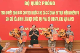 Cérémonie de remise de décisions présidentielles à trois officiers déployés auprès de la FISNUA. Photo: VNA