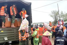 Des officiers et soldats acheminent des vivres aux habitants des zones inondées de Dak Lak. Photo: VNA