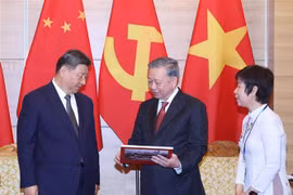 Le secrétaire général du PCV Tô Lâm offre au secrétaire général du PCC et président Xi Jinping un livre photo de l'Agence vietnamienne d'Information (VNA), comprenant des photos des visites de Xi Jinping au Vietnam. Photo: VNA
