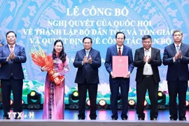 Le Premier ministre Pham Minh Chinh remet la décision de créer le ministère des des Affaires ethniques et religieuses à ses responsables. Photo: VNA