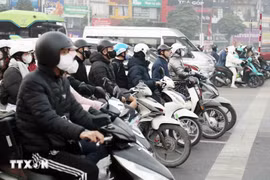 Des habitants respectent les feux de signalisation au carrefour Khuât Duy Tiên – Nguyê Trai, à Hanoï. Photo: VNA