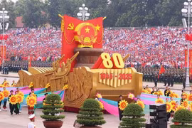 Un véhicule miniature portant l'emblème national de la République socialiste du Vietnam mène le défilé militaire et le cortège de masse. Photo : VNA