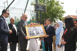 L'ambassadeur du Vietnam, Trân Quôc Khanh, remet à Djamel Belamou, président du quartier Rais Hamidou où se trouve l'avenue Hô Chi Minh à Alger, une photo de l'Oncle Ho recevant une délégation algérienne en visite au Vietnam en 1958. Photo: VNA