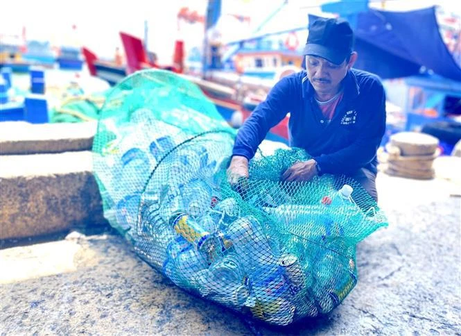 Des pêcheurs de Binh Dinh ramènent à terre leurs déchets plastiques. Photo: VNA