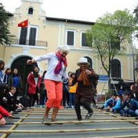 Les visiteurs internationaux découvrent des activités culturelles et des jeux folkloriques à Hanoi. (Photo : Thanh Dat/https://nhandan.vn/)