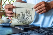 Contrairement aux estampes polychromes, la peinture de Sinh utilise la matrice uniquement pour imprimer les contours, la coloration étant ensuite réalisée à la main, ce qui rend chaque œuvre unique. Photo : VNA