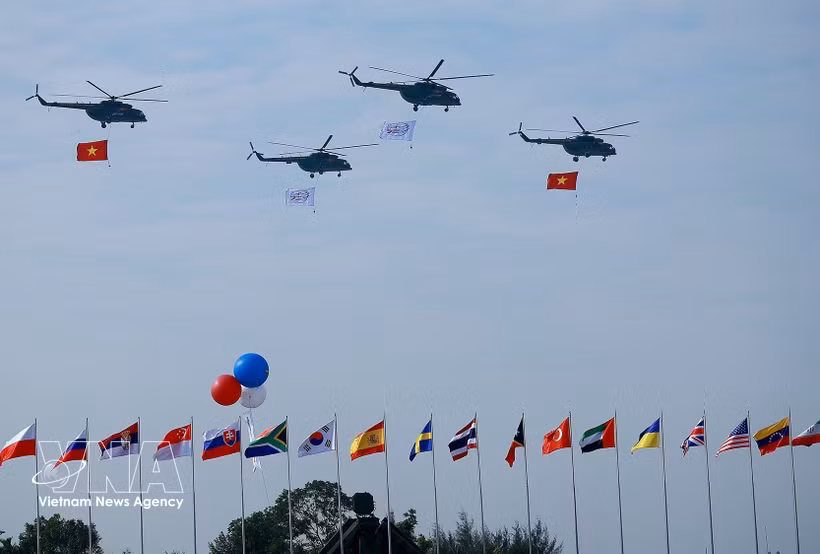 Un vol de formation d’hélicoptères arborant le drapeau national vietnamien effectue une démonstration aérienne lors de la cérémonie d’ouverture de l’Exposition internationale de défense du Vietnam 2024. Photo : VNA