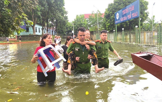 Des officiers et des soldats stationnés au bourg de Thác Bà, district de Yên Bình, province de Yên Bai aident les résidents locaux à reloger les personnes et les biens en lieu sûr. Photo: VNA
