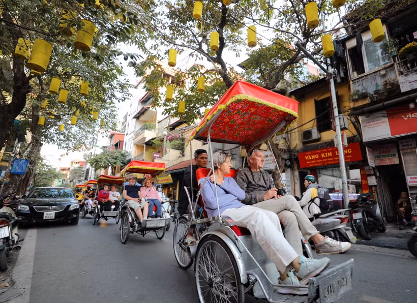 Des touristes étrangers utilisent des cyclos pour admirer la beauté antique du Vieux quartier de Hanoï. Photo : VNA