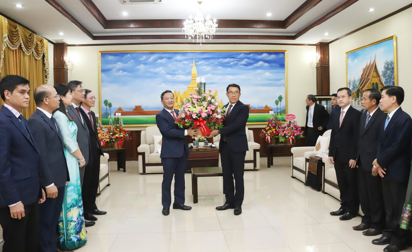 L'ambassadeur Nguyen Minh Tam remet des fleurs de félicitations du secrétaire général To Lam à la partie lao. Photo : VNA