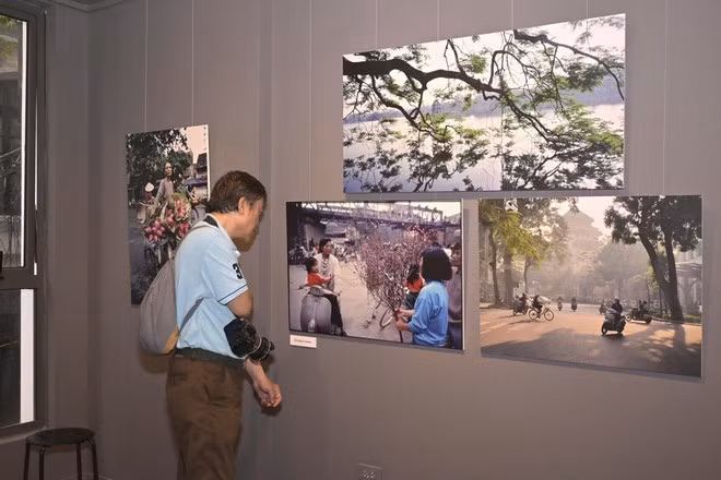 Un visiteur admire les photos de Nicolas Cornet lors de l'exposition « Hanoi Oi », un événement organisé à l'occasion du lancement du livre du même nom. Photo : VietnamPlus