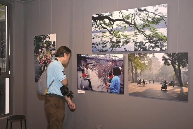 Un visiteur admire les photos de Nicolas Cornet lors de l'exposition « Hanoi Oi », un événement organisé à l'occasion du lancement du livre du même nom. Photo : VietnamPlus