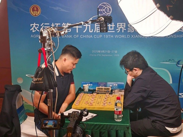 Le roi vietnamien du xiangqi, Lai Ly Huynh (gauche), remporte son premier titre mondial dans cette discipline en dominant le Chinois Yin Sheng lors de la finale du Championnat du monde de xiangqi 2025. Photo: VXF/chinhphu.vn