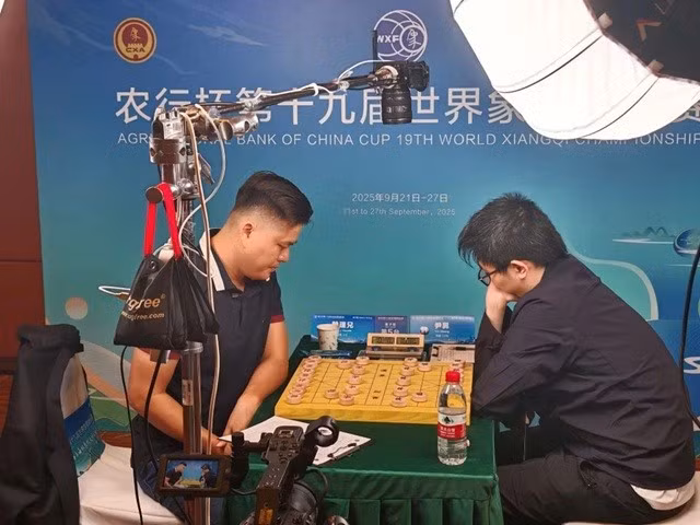 Le roi vietnamien du xiangqi, Lai Ly Huynh (gauche), remporte son premier titre mondial dans cette discipline en dominant le Chinois Yin Sheng lors de la finale du Championnat du monde de xiangqi 2025. Photo: VXF/chinhphu.vn