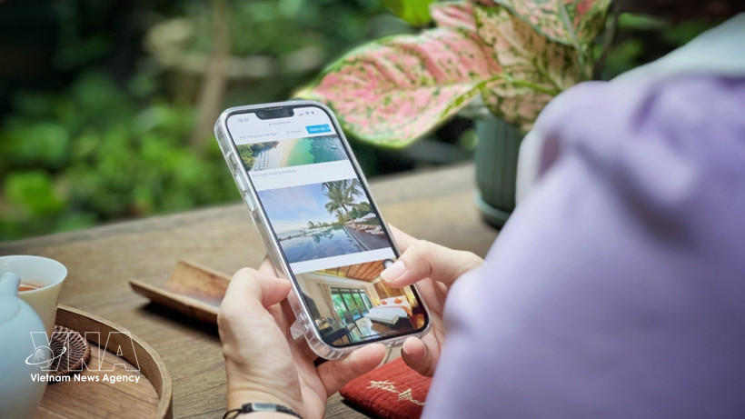 Avec un simple smartphone en main, les touristes peuvent rechercher et réserver divers services pour leur voyage. Photo : VNA