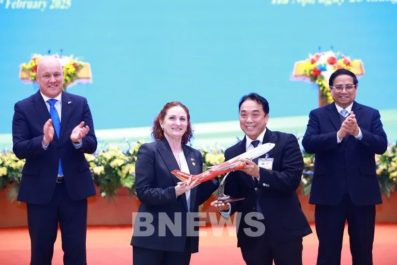 L'ambassadrice de Nouvelle-Zélande au Vietnam, Caroline Beresford, remet le certificat d'ouverture de la nouvelle ligne aérienne direct reliant Ho Chi Minh-Ville à Auckland au vice-président du conseil d'administration de Vietjet, Nguyen Anh Tuan, en présence des Premiers ministres du Vietnam et de la Nouvelle-Zélande. Photo : VNA