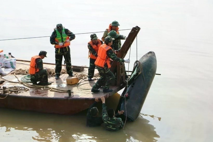 Les forces militaires de la province de Nghe An (Centre) et la bombe de 226 kg datant de la guerre. Photo: VNA
